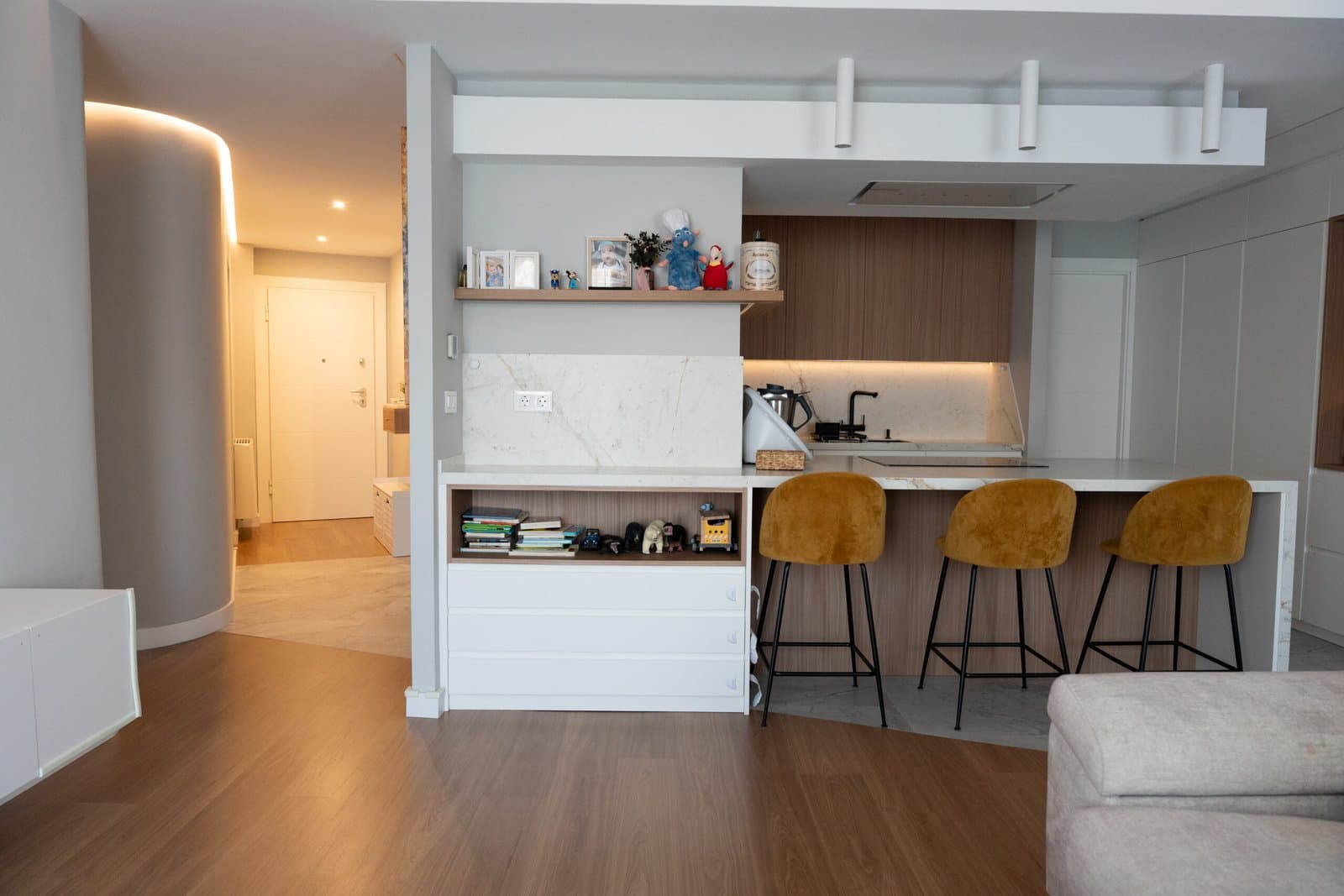 Living and dining room with a marble kitchen island and three mustard stools