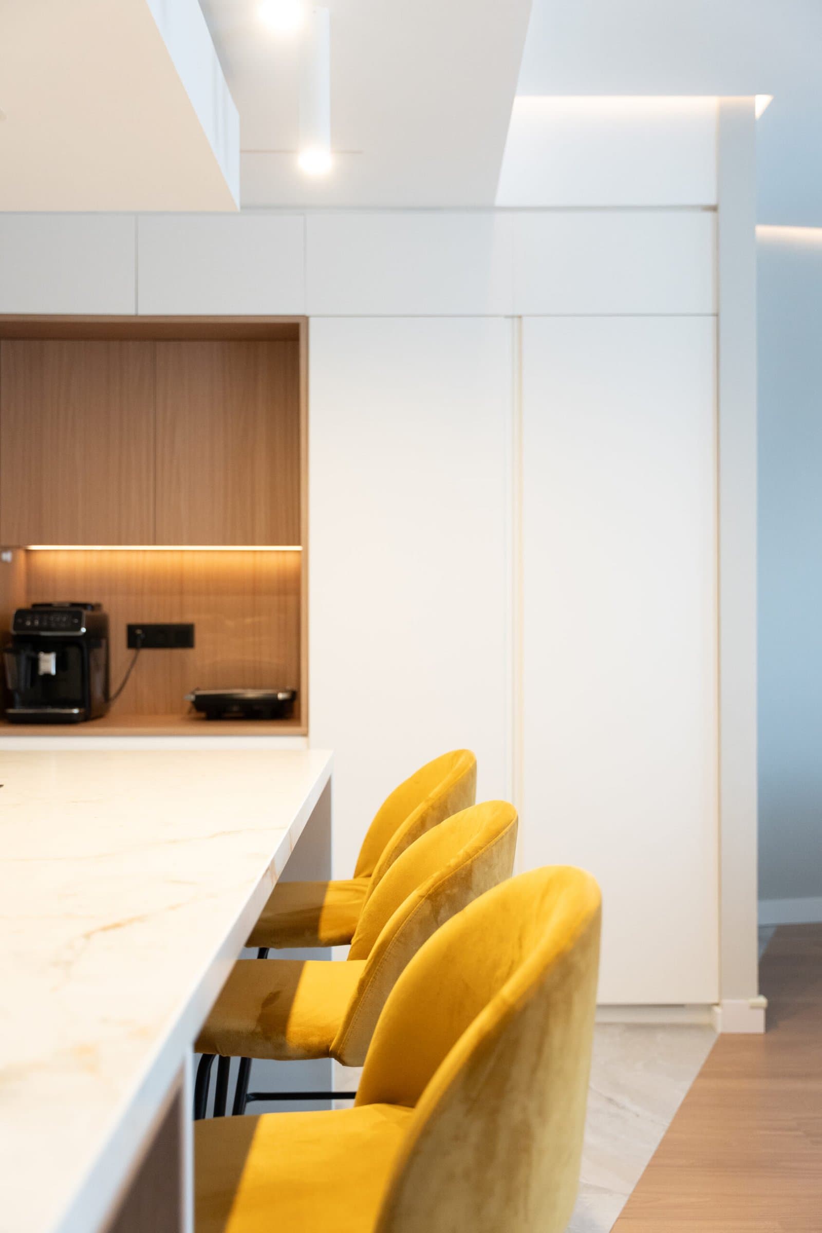 Marble and wood kitchen counter with mustard velvet stools
