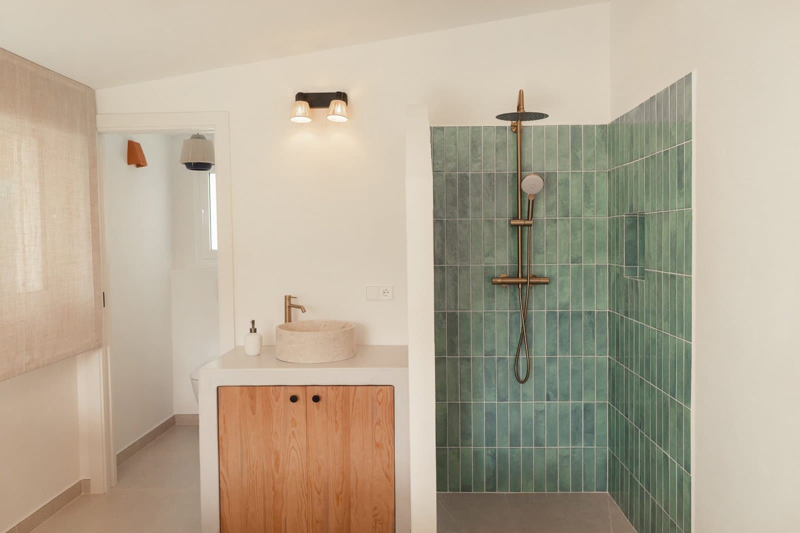 Bathroom with a green tiled shower and a wooden washbasin unit