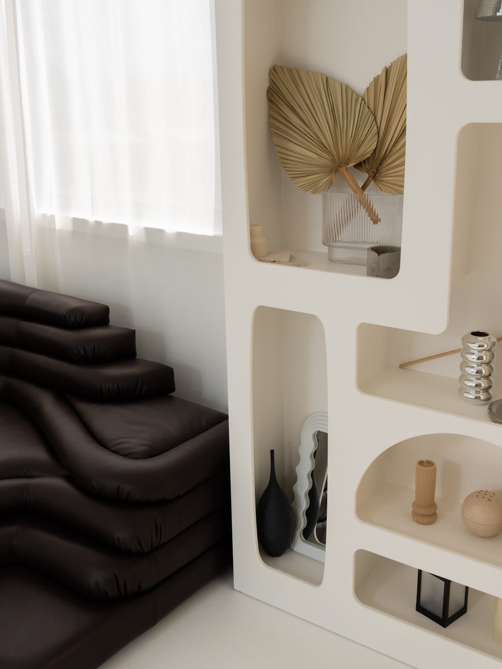 Shelving niche with dried palm leaves and ceramic objects